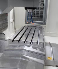 Рабочая зона Huashuo VMC850: стол с пятью Т-пазами, шпиндель с соплами СОЖ, телескопические щитки