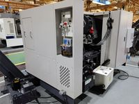 Токарный станок SMTCL iT сзади: ниша с пневмоблоком и станцией смазки, открытая дверь обслуживания и гидростанция