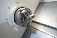 Трёхкулачковый патрон токарного станка SMTCL T5 крупным планом, справа наклонная поверхность станины