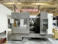 Токарный станок SMTCL HTC50B/1000 в цеху завода, вид спереди: окно рабочей зоны и пульт ЧПУ