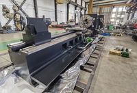 Трубонарезной станок SMTCL со стороны задней бабки и тыльной стенки станины с прямоугольными окнами, вдали передняя бабка с патроном и электродвигателем