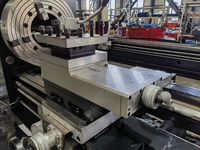 Суппорт трубонарезного станка SMTCL: верхние салазки с лимбом, резцедержатель с зажимными винтами, на заднем плане патрон