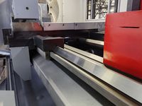 Направляющие станины трубонарезного станка SMTCL: стальные планки, основание суппорта и красная задняя бабка справа