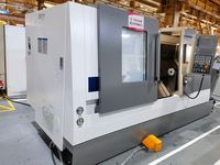 Токарный станок SMTCL T5-1000Q в цеху, вид 3/4 спереди: дверь рабочей зоны с окном, пульт ЧПУ и длинная станина